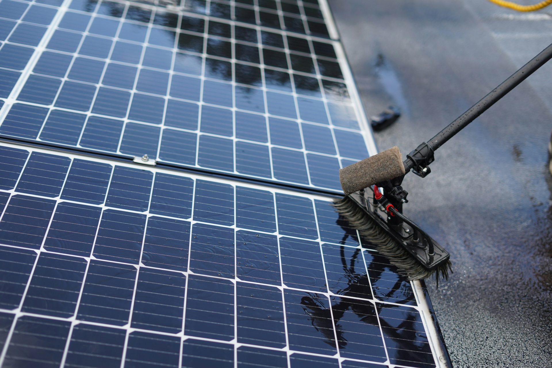 Nettoyage des panneaux solaires avec une brosse à long manche.